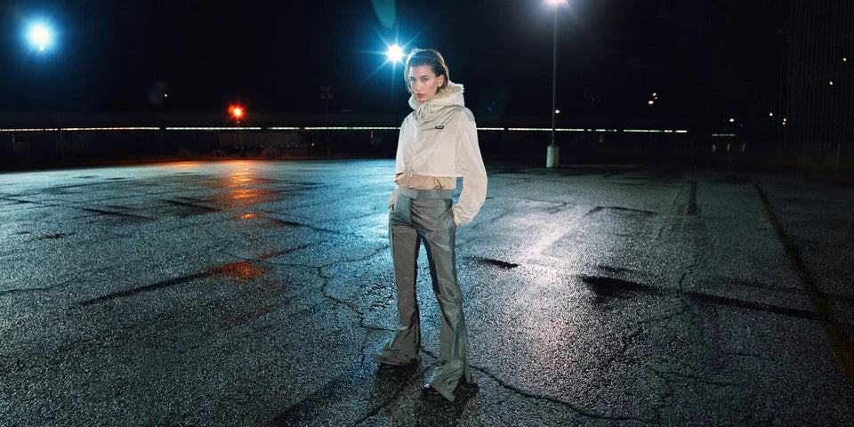 Miu Miu Fall/Winter 2026 campaign: ivory jacket and olive trousers against a blue nocturnal setting. Photograph by Zoe Ghertner.