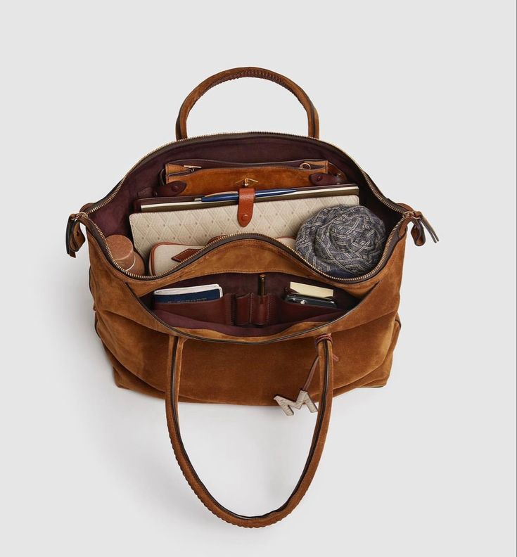 Open tan Private Eye with laptop, notebooks and everyday essentials