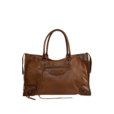 Image 1 of 3 - BROWN - Balenciaga Men's Le City Bag Large is crafted from vintage goatskin and features the house's iconic relaxed silhouette with two hand-braided handles detailed with waxed cord. Designed for hand or crossbody carry, this designer bag features an adjustable and removable shoulder strap with shoulder pad, brass hardware, a double-sided zip closure with long tails and knotted leather puller, front zipped pocket, interior zipped pocket, removable mirror with tone-on-tone Balenciaga logo, and