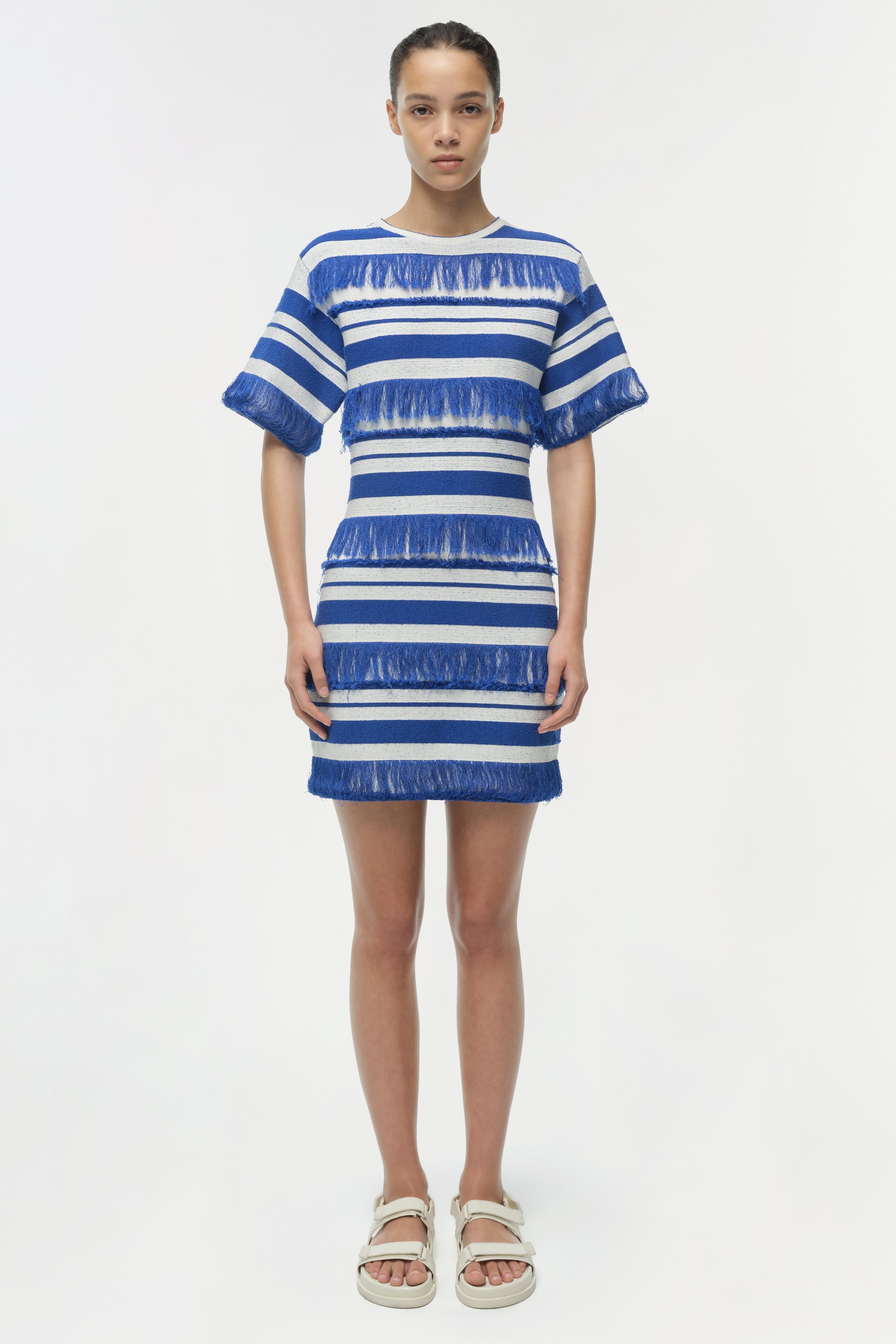 Woman wearing a blue and white striped knit mini dress with textured stripes and short sleeves.