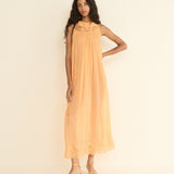 Woman wearing a peach-colored dress against a plain background