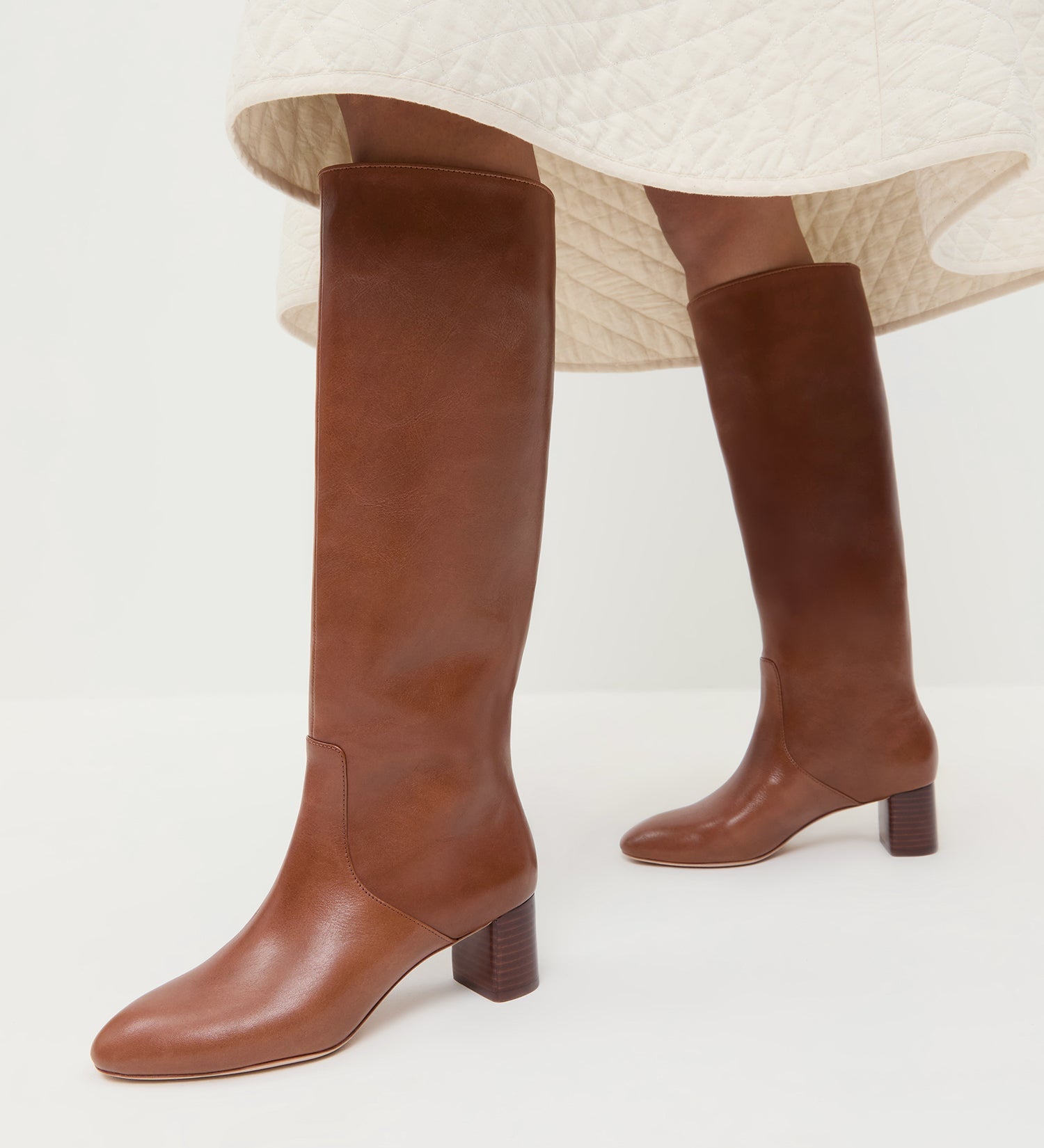 Gia Safari Leather Tall Boot in safari brown leather and Clara Quilted Skirt in cream.