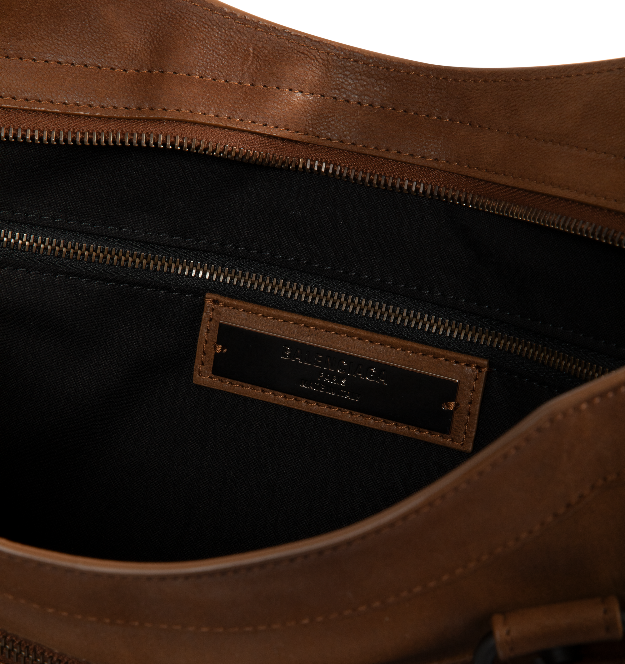 Image 3 of 3 - BROWN - Balenciaga Men's Le City Bag Large is crafted from vintage goatskin and features the house's iconic relaxed silhouette with two hand-braided handles detailed with waxed cord. Designed for hand or crossbody carry, this designer bag features an adjustable and removable shoulder strap with shoulder pad, brass hardware, a double-sided zip closure with long tails and knotted leather puller, front zipped pocket, interior zipped pocket, removable mirror with tone-on-tone Balenciaga logo, and