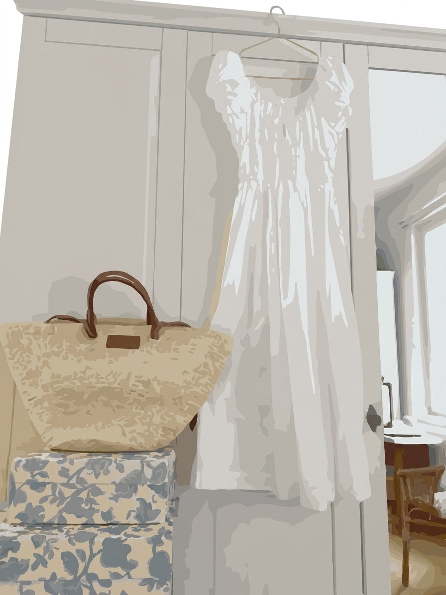 A white sleeveless dress hanging on a hanger in front of a light-colored wardrobe, with a beige patterned tote bag resting on stacked floral boxes below.