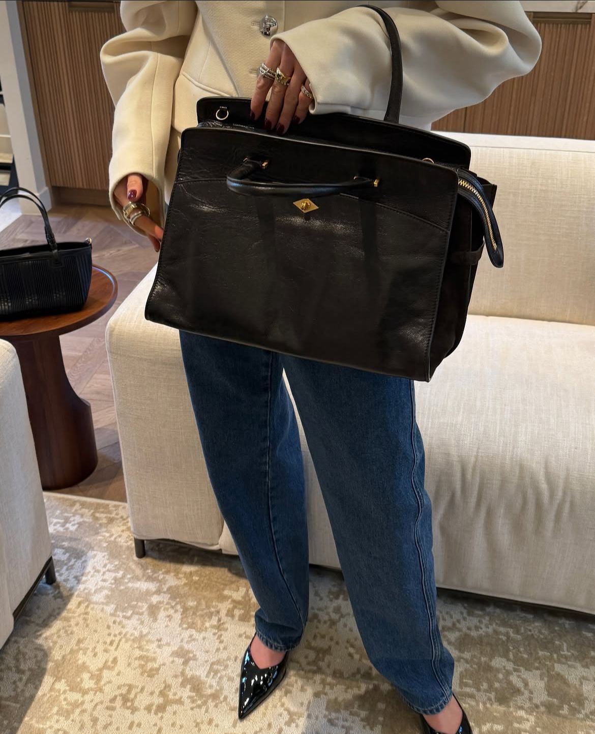 Person holding a black handbag in an indoor setting