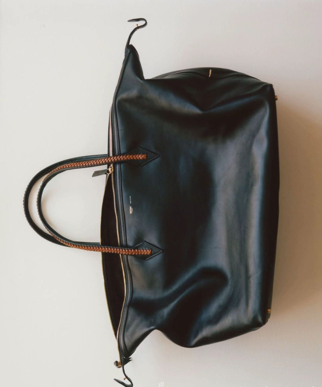 Black leather bag with brown handles on a white background