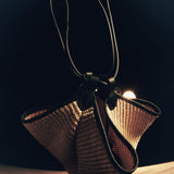 The Mini Lotus Drawstring Bag in Natural Raffia and Black Leather