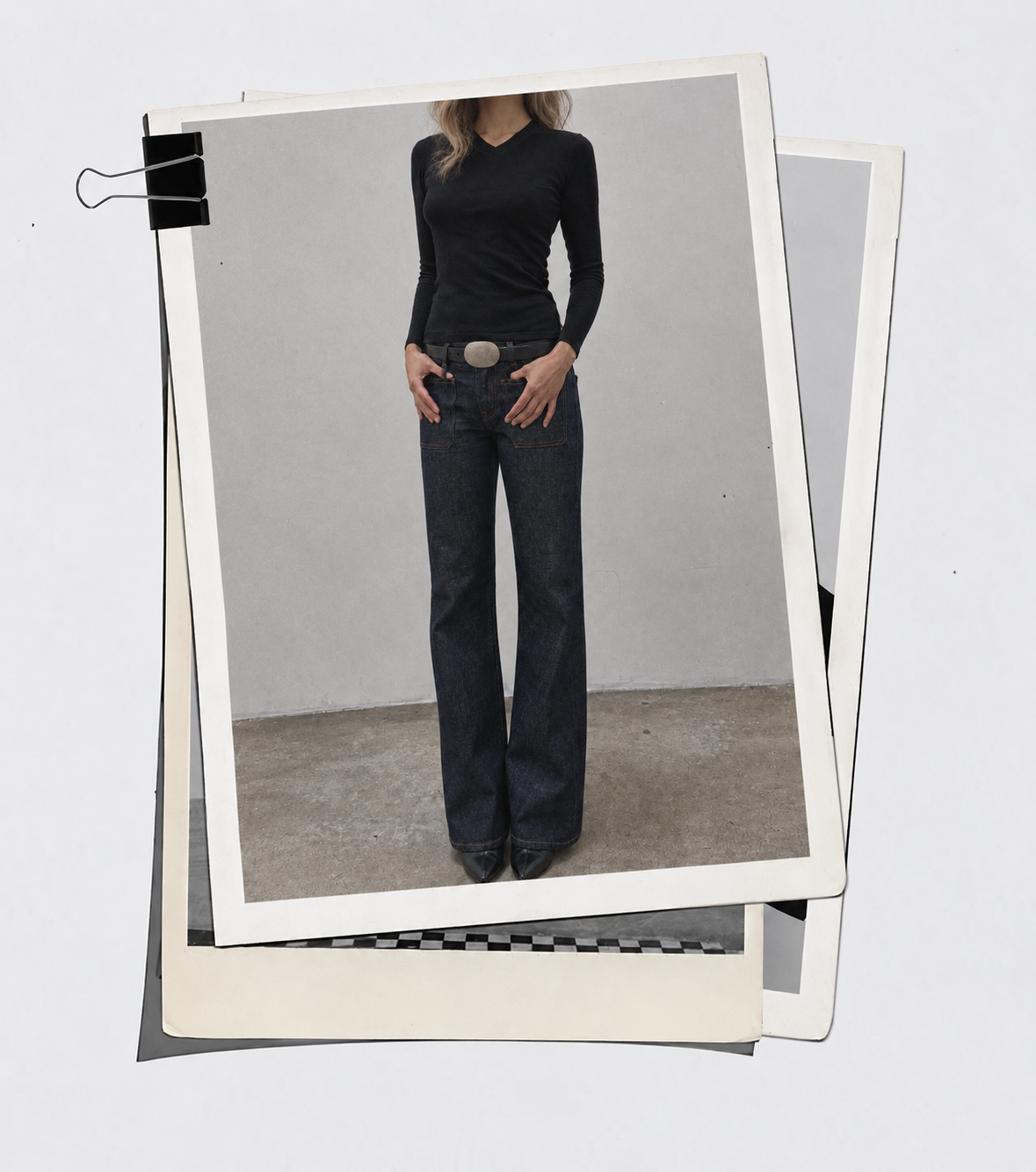 Black fitted top, dark jeans and oval buckle belt shown in a clipped photographic print