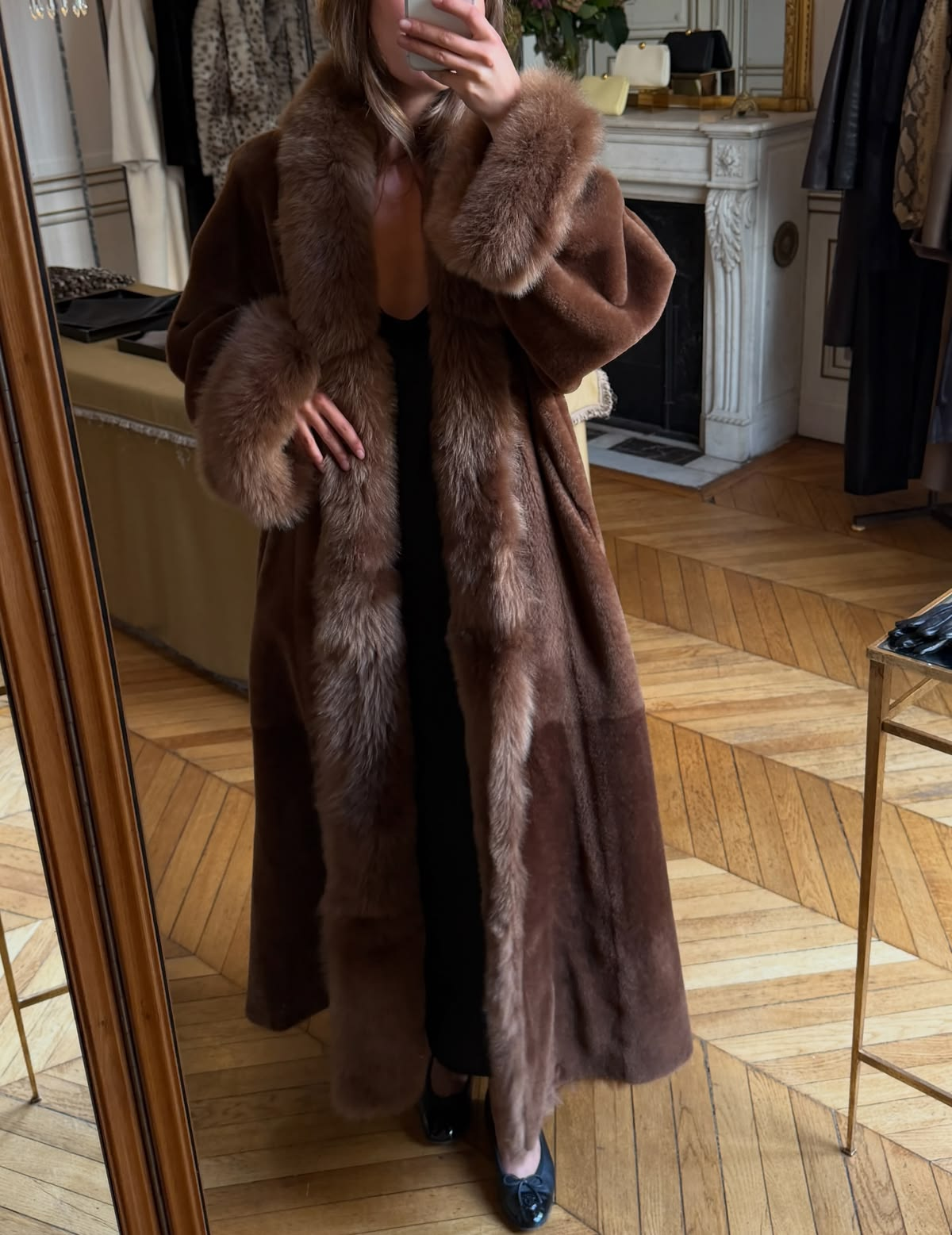 Nour Hammour brown statement coat worn in an apartment
